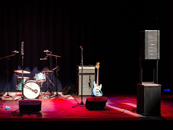 Quiet stage prepared with electronic drums, guitars, amplifiers and sound system